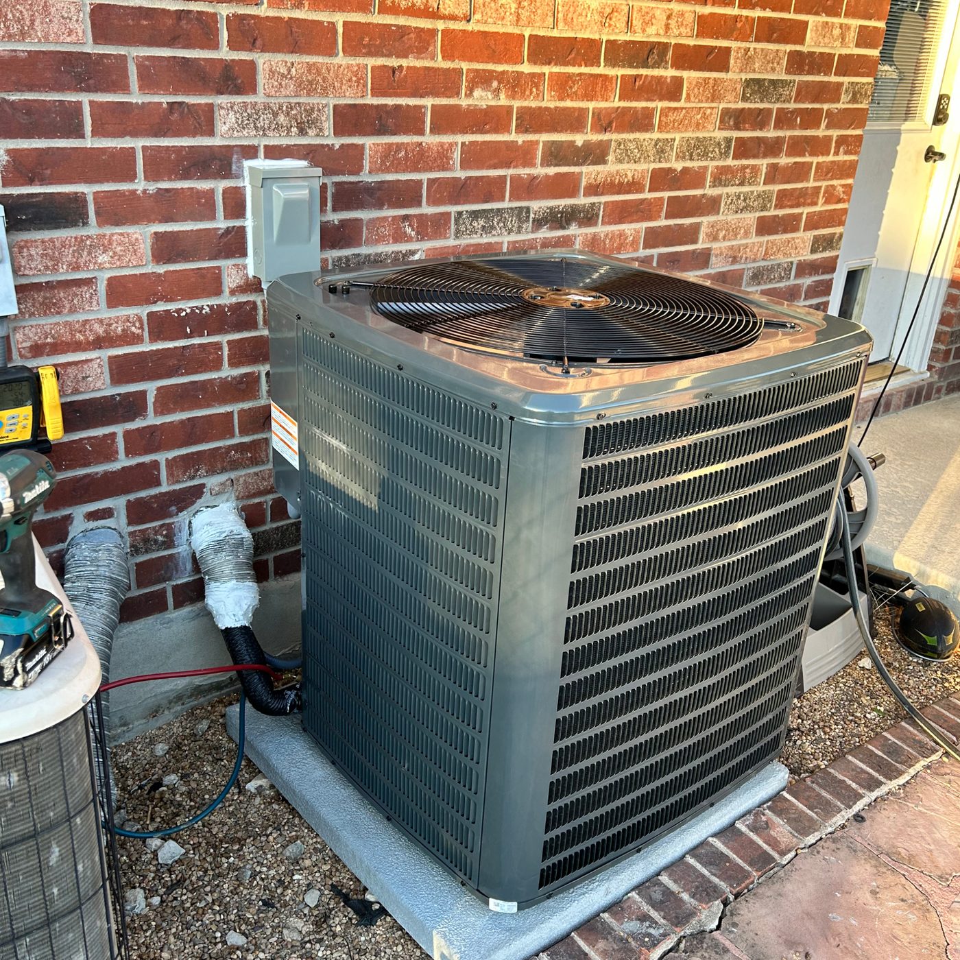 An Airstrike technician diagnosing a residential air conditioning condenser